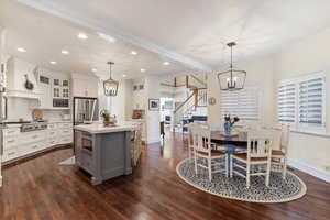 Dining room featuring a chandelier, crown molding, and dark wood-type flooring