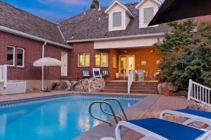 Pool at dusk featuring a patio and an outdoor pool