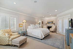 Carpeted bedroom with access to exterior, recessed lighting, a fireplace, and crown molding