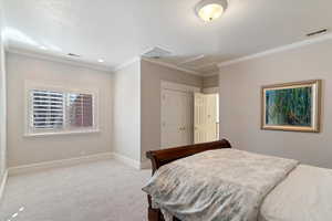Bedroom with a closet, crown molding, light colored carpet, and recessed lighting