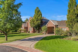 View of front facade with brick siding and a front lawn