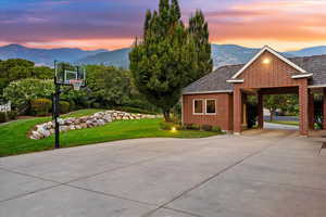 View of basketball court featuring a mountain view and a yard