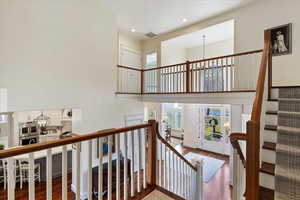 Stairs featuring a chandelier, a high ceiling, and wood finished floors