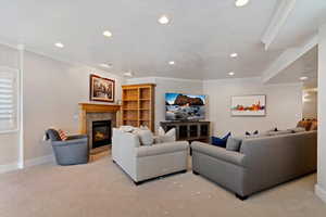 Living room featuring ornamental molding, light colored carpet, a tile fireplace, and recessed lighting