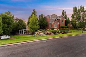 View of front facade featuring a front lawn and brick siding