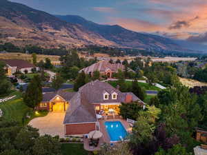 Aerial view of property and surrounding area featuring a mountainous background and a pool