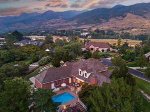View of subject property featuring a mountain backdrop and a tree filled landscape