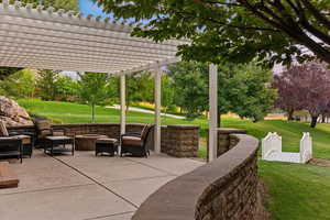 View of patio featuring a pergola and a fire pit