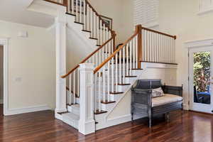 Stairs with wood finished floors and a high ceiling