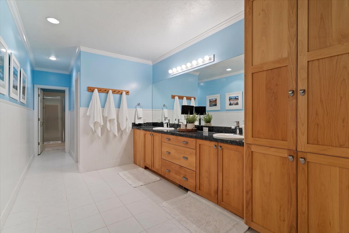 Full bathroom with double vanity, crown molding, recessed lighting, light tile patterned floors, and a shower stall