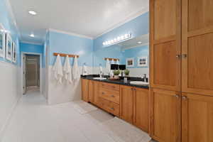 Full bathroom with double vanity, crown molding, recessed lighting, light tile patterned floors, and a shower stall