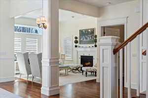 Foyer entrance with dark wood-style flooring, crown molding, and a tiled fireplace