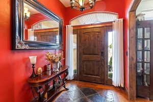 Entryway featuring suspended lighting and dark wood-style flooring