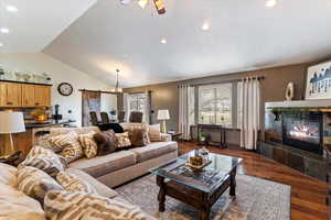 Living room featuring a fireplace, dark wood finished floors, recessed lighting, vaulted ceiling, and a ceiling fan