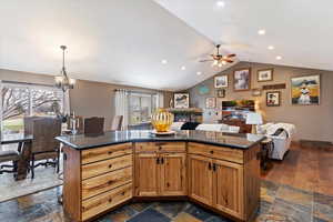 Kitchen featuring open floor plan, a kitchen island, hanging lights, and a kitchen bar