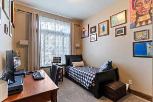 Bedroom with carpet flooring and a desk