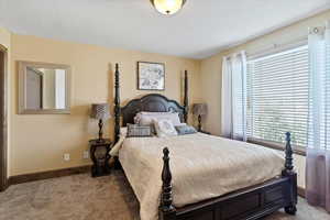 Bedroom featuring dark carpet and baseboards