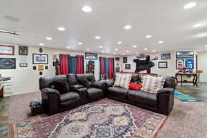 Living room featuring stone finish flooring, recessed lighting, and dark carpet
