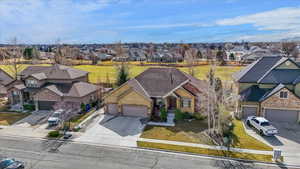View of front of property featuring driveway, a garage, a residential view, and a front yard