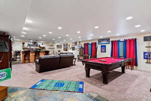 Recreation room with light carpet, billiards table, bar area, and recessed lighting