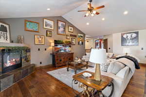 Living area featuring wood-type flooring, a ceiling fan, a tile fireplace, and recessed lighting