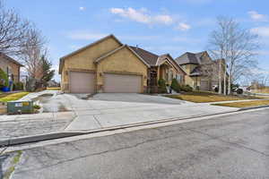 View of front of property featuring a garage, concrete driveway, and stucco siding