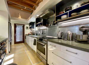 Kitchen featuring stainless steel appliances, ventilation hood, open shelves, white cabinets, and tasteful backsplash