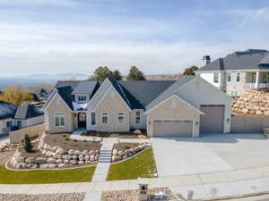 View of front of house featuring a garage, stone siding, driveway, and a residential view