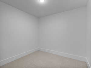 Spare room featuring baseboards and carpet