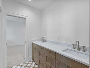 Bathroom with double vanity and baseboards