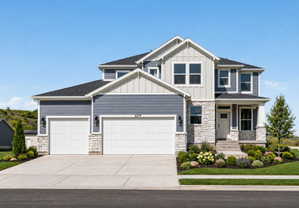 Crafted exterior featuring a two-car garage, stone accents, and dark gray siding
