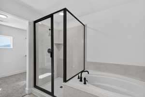 Full bathroom featuring a marble finish shower, a bath, and light colored carpet
