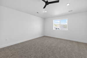 Unfurnished room featuring dark colored carpet, a ceiling fan, and recessed lighting
