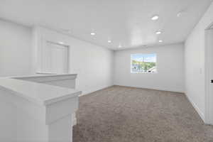 Carpeted spare room featuring baseboards and recessed lighting