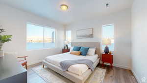 Bedroom featuring light wood-style floors and a water view