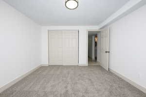 Unfurnished bedroom with light colored carpet and a closet