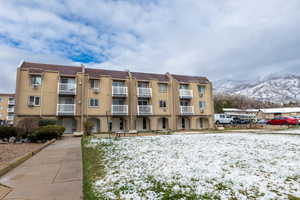 Snow covered building with a view of apartment building / complex and a mountain view