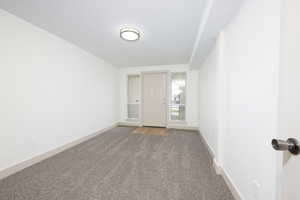 Spare room with dark carpet and baseboards