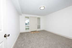 Unfurnished room featuring light carpet and baseboards
