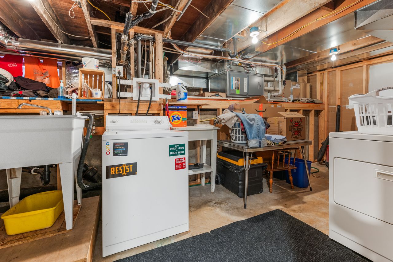 Unfinished below grade area with electric panel and a workshop area