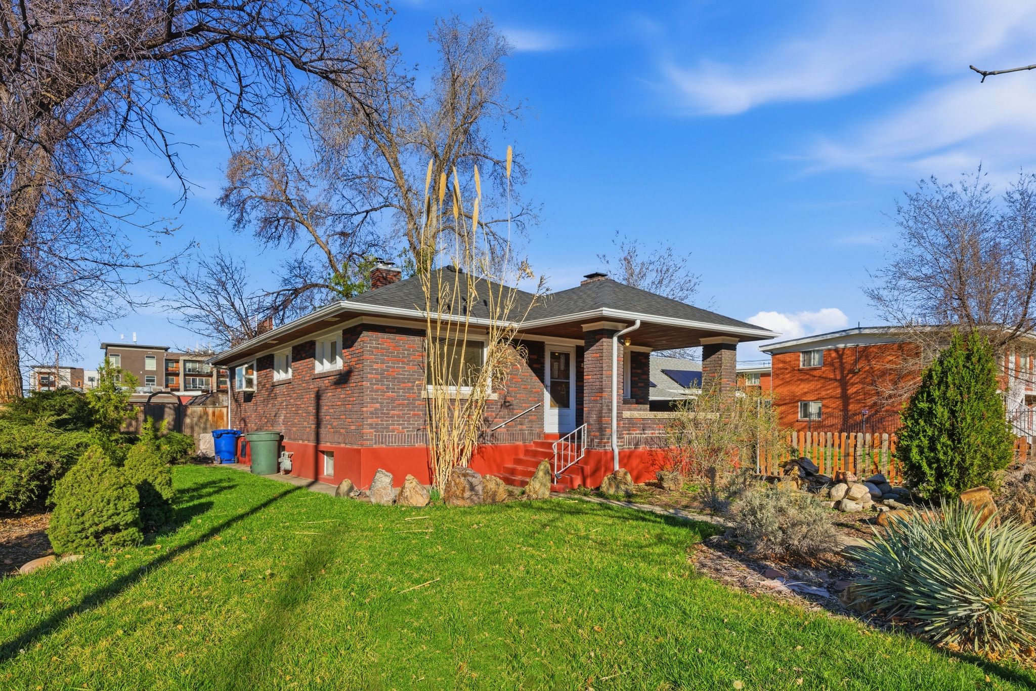 Ranch-style home with a front lawn, a chimney, and brick siding