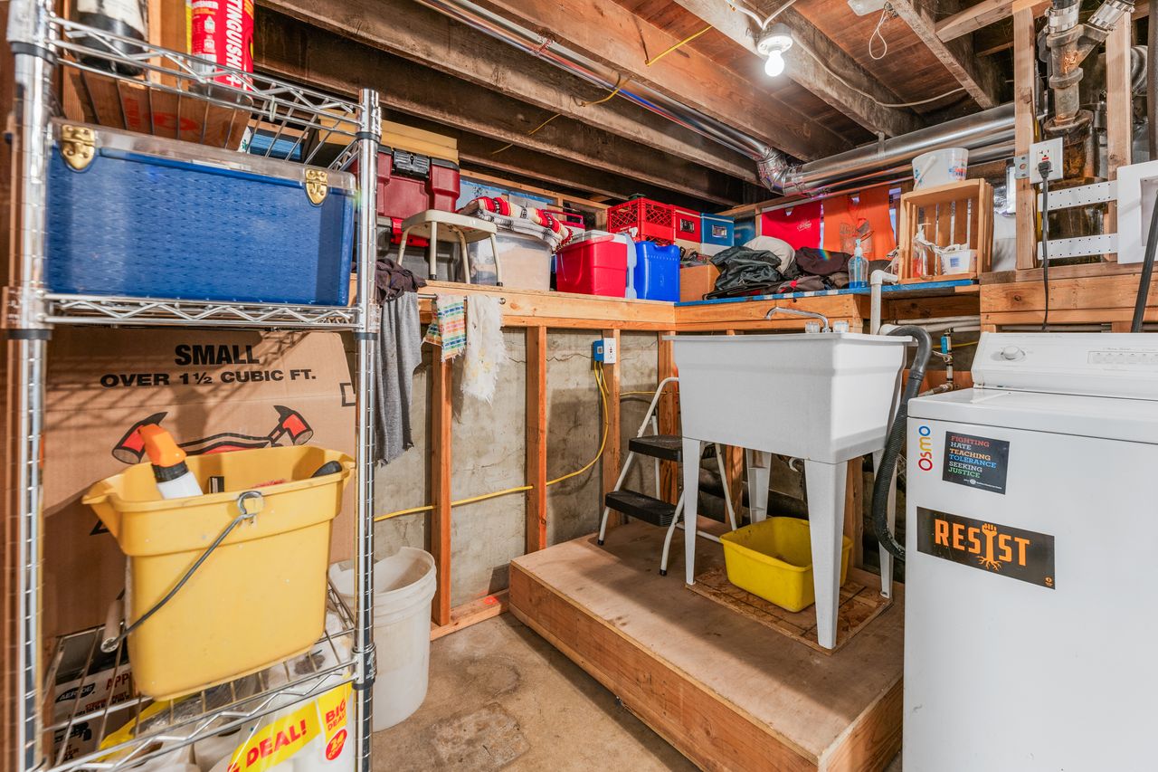 Unfinished basement with washer / clothes dryer and a sink