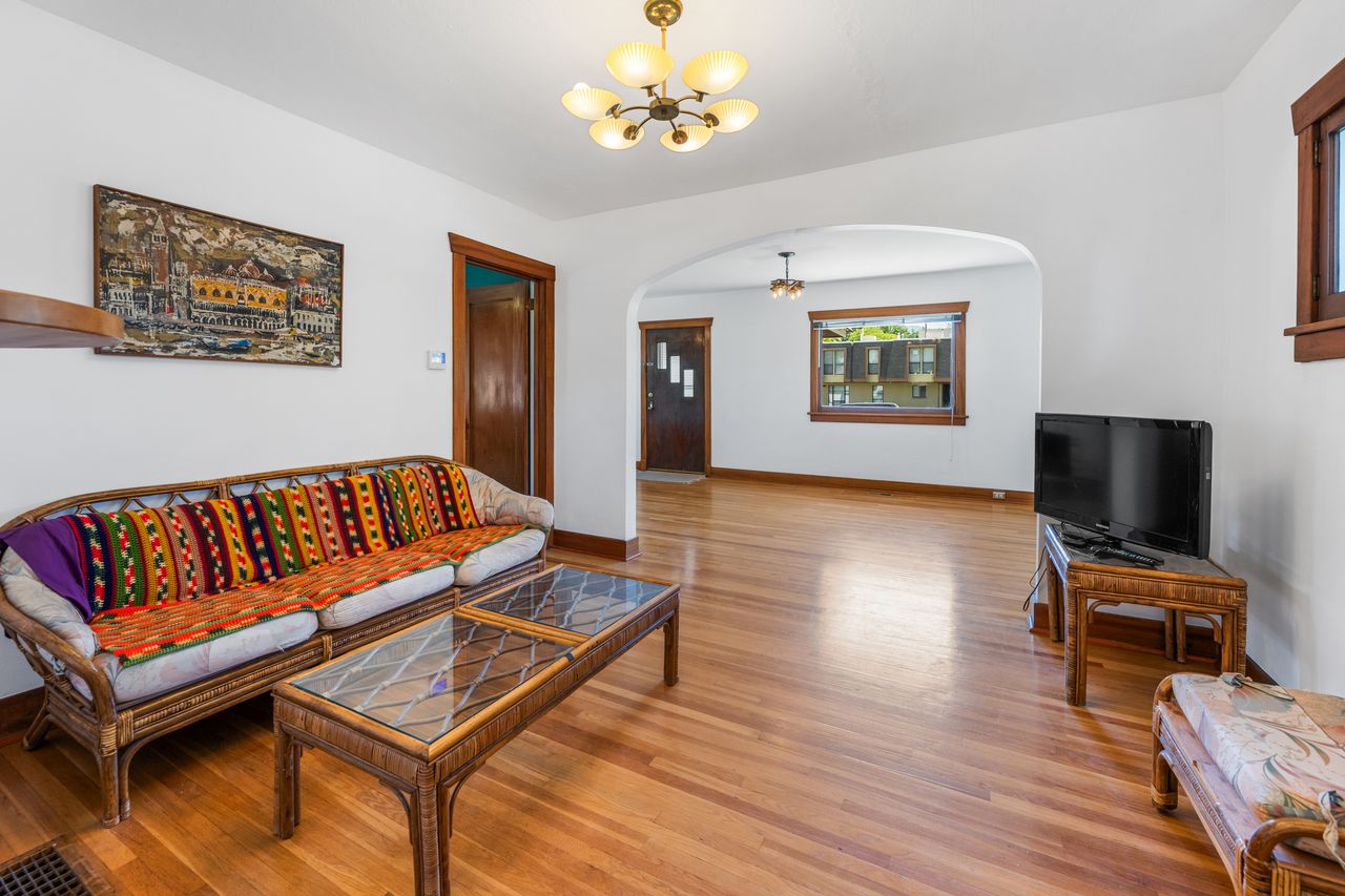 Living room featuring arched walkways, hardwood / wood-style flooring, and a chandelier