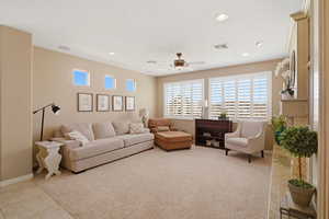 Living area featuring a ceiling fan, recessed lighting, and light carpet