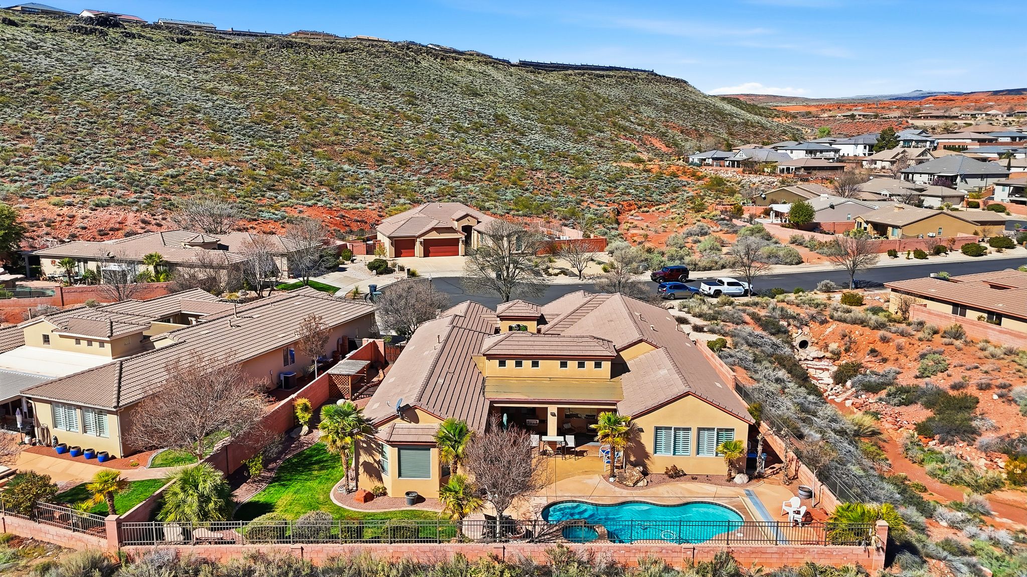 Aerial view of residential area featuring a mountain backdrop and a pool area