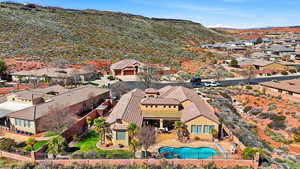 Aerial view of residential area featuring a mountain backdrop and a pool area