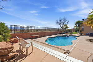 Relaxing pool / spa featuring a patio area and a fenced backyard