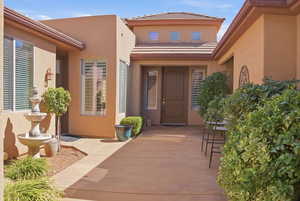 View of exterior entry with stucco siding and a tiled roof