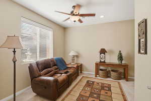 Sitting room with light colored carpet, a ceiling fan, and recessed lighting