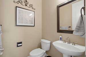 Half bath featuring toilet and a sink